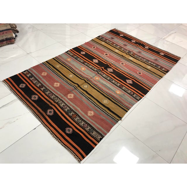 This is a vintage Turkish Anatolian kilim rug from the 1960s. The piece was hand-woven.