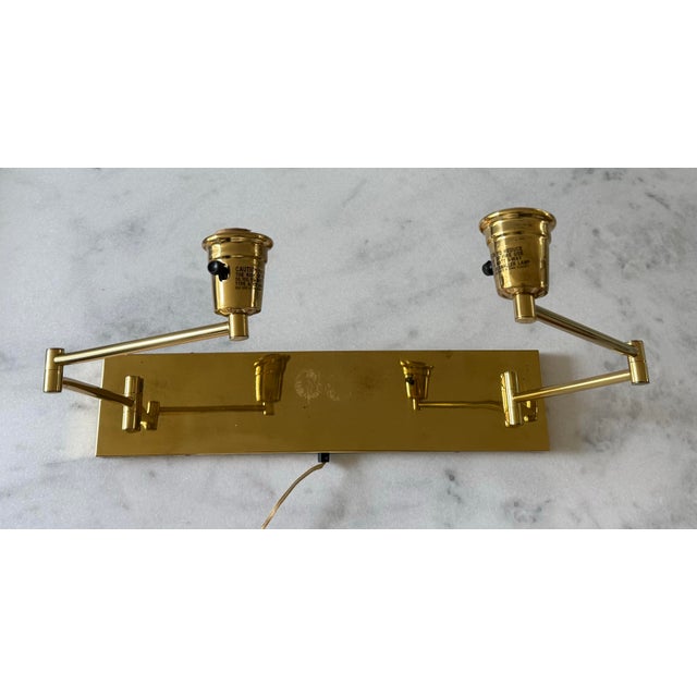 Vintage polished brass adjustable double arm picture or task lighting sconce. Arms extend to 18"depth