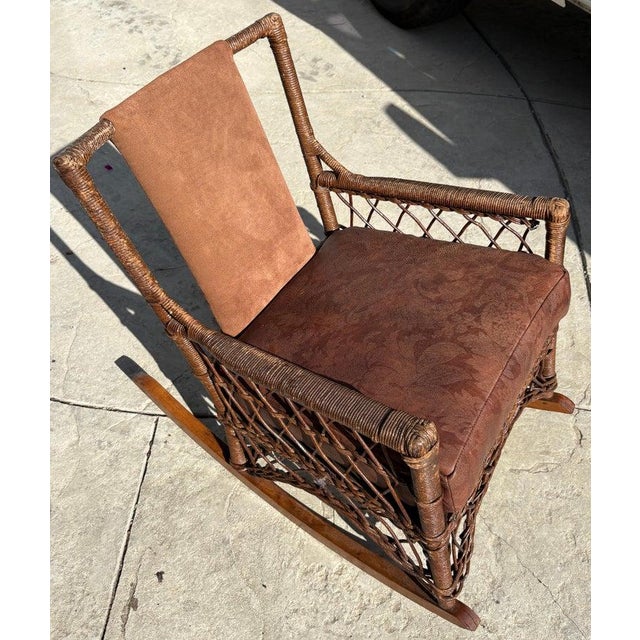 Original old surface wicker rocker with leather cushion Bar Harbor style and signed on base with a metal plaque.Condition...