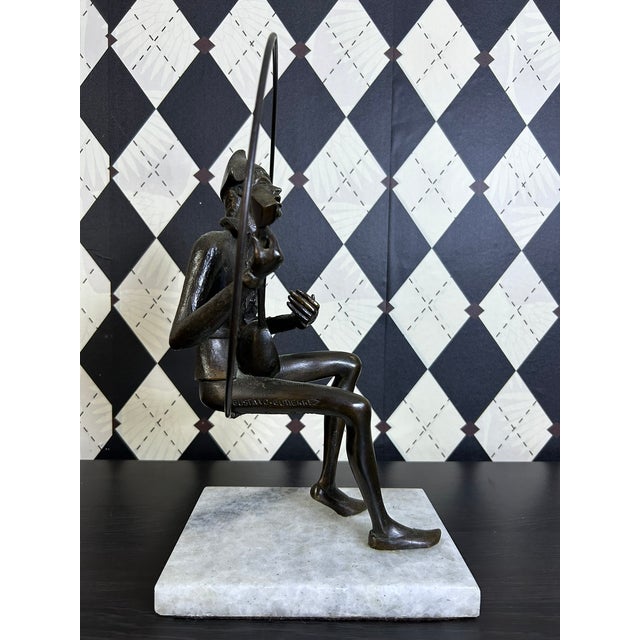 A signed limited edition bronze sculpture by Gustavo Gutierrez depicting a seated harlequin musician holding a lute. The...
