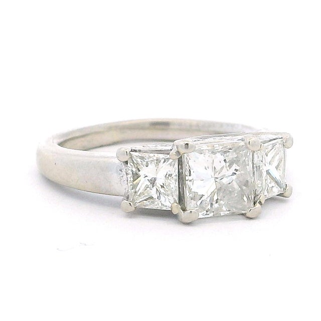 A beautifully balanced vintage three-stone diamond ring crafted in 14K white gold, featuring three princess-cut diamonds...