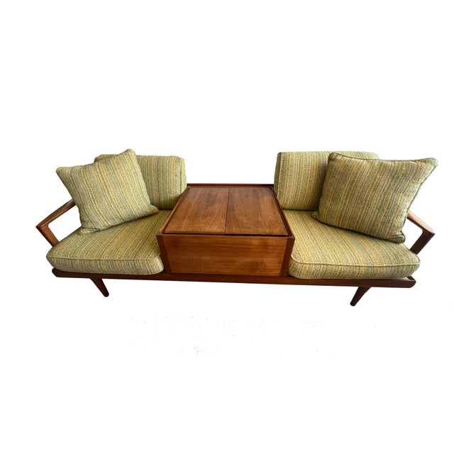 A striking mid-century modern walnut conversation sofa, expertly crafted with clean architectural lines and warm wood...