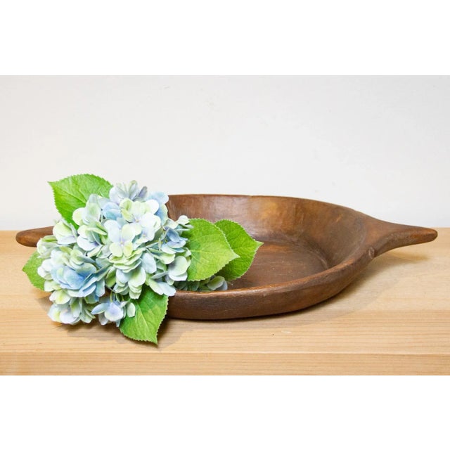 A vintage round wooden bowl originally used for kneading dough to make bread. It features one side handle and a beautiful...