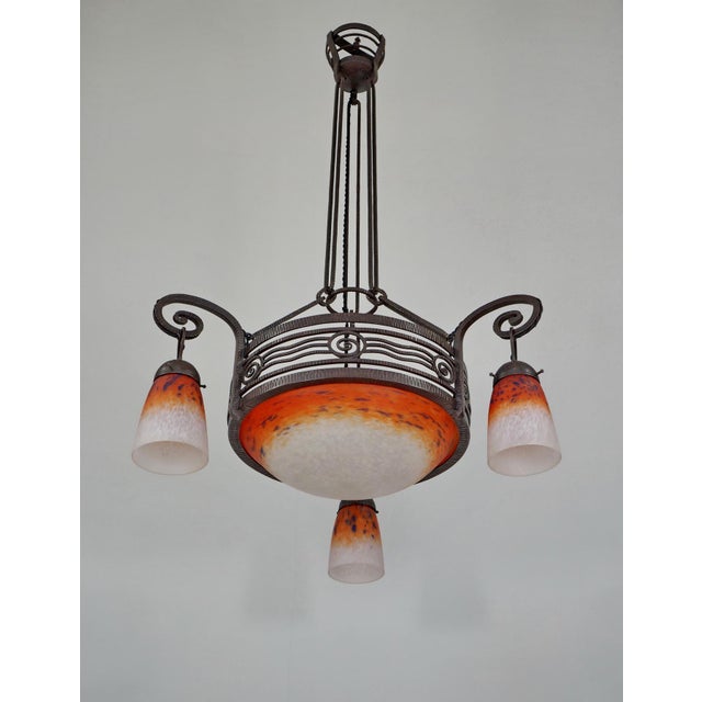 Hippolyte Fournet & Charles Schneider A French art deco chandelier made circa 1925-1930. Done in wrought iron and glass...