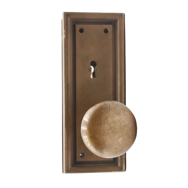 Brass Corbin door knob set with two plain round door knobs and back plates with keyholes. The door plates are inscribed...