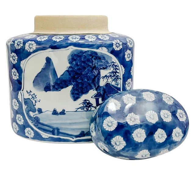 A classic early 20th century porcelain Chinoiserie porcelain tea caddy canister with lid featuring a blue willow style...
