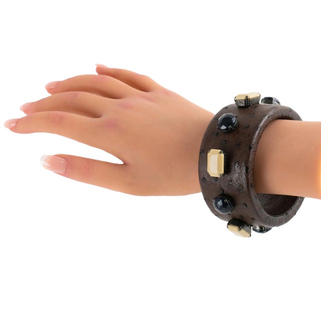 Prada, Italy, designed this stunning leather bangle bracelet. This striking fashion accessory combines the luxurious...