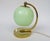 An elegant bedside lamp designed in the strict design language of Art Deco. The lampshade is made of green overlaid glass...