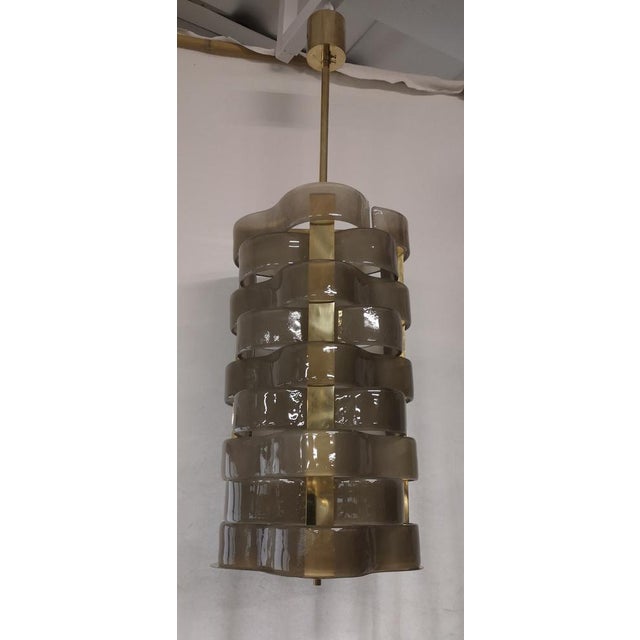 Design in woven Murano glass for this smoky colored chandelier, its style is elegant and linear. The chandelier is in...