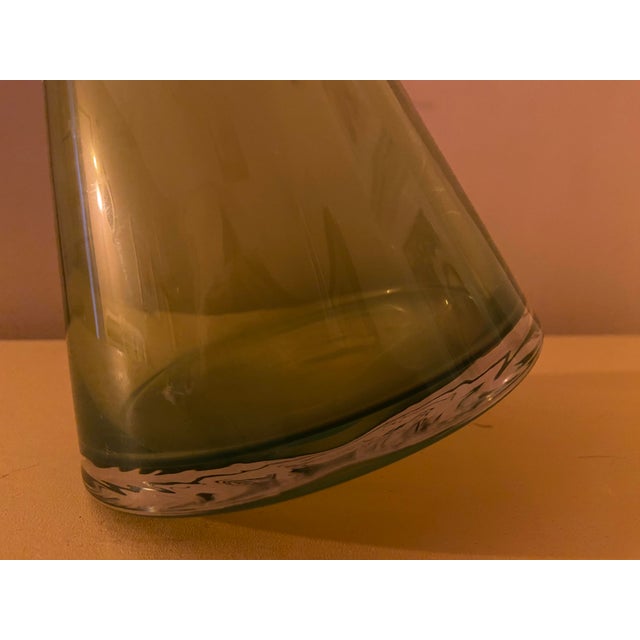 A striking vintage art glass vase in a rich olive/avocado green, featuring an unusual asymmetrical conical silhouette and...