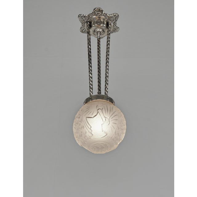 H. Petitot & Muller Frères A French 1930s art deco pendant in nickel plated bronze. The nice mount holds a globe by the...