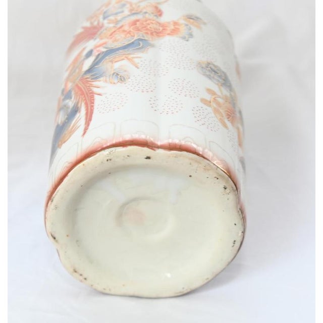 A decorative pair of Japanese Meiji style porcelain vases with tall cylindrical bodies and flared rims The white grounds...