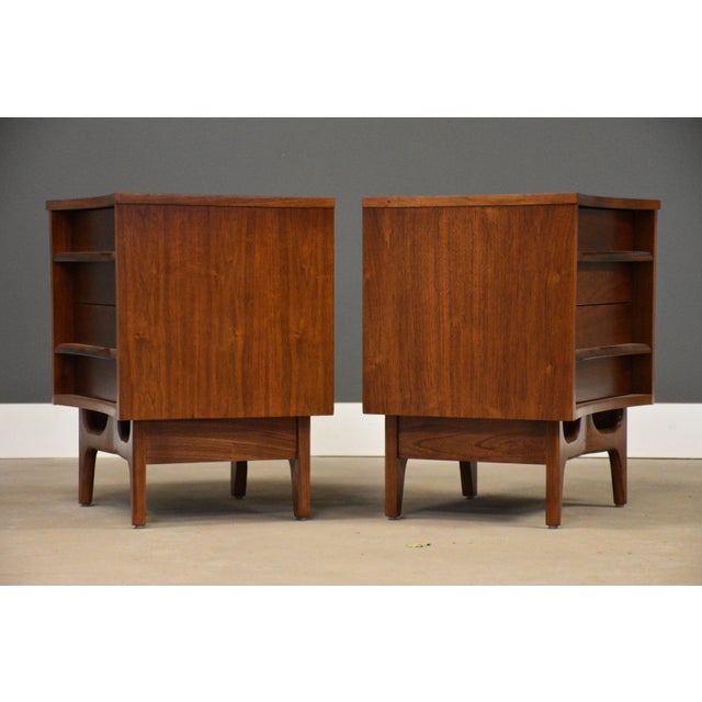 A pair of mid century modern walnut two drawer nightstands with sculpted pulls and dovetail drawers made by Young...