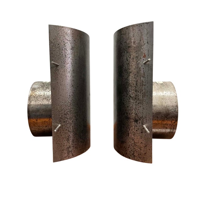 This striking pair of vintage Brutalist wall sconces features sculptural curved steel shades with a beautifully mottled...