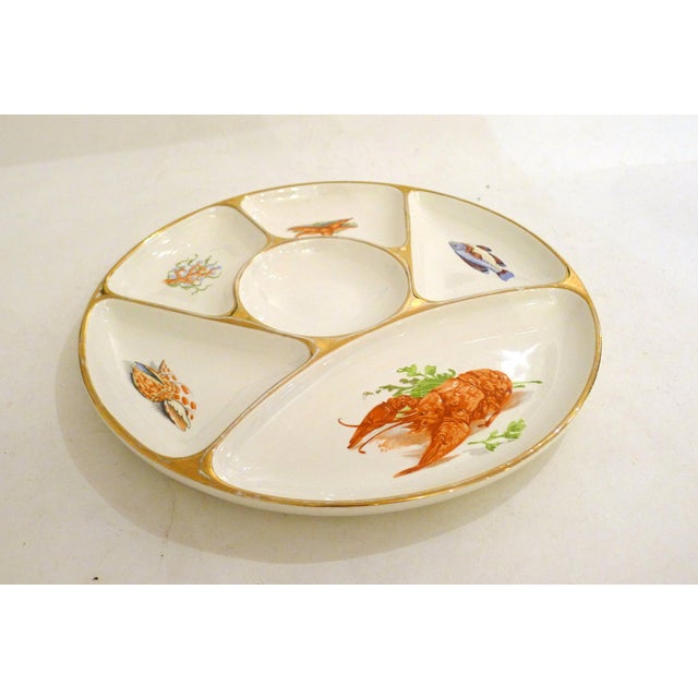 Seafood appetizer/hors d'oeuvre plate: serving plate with six compartments, including a central round one, each decorated...