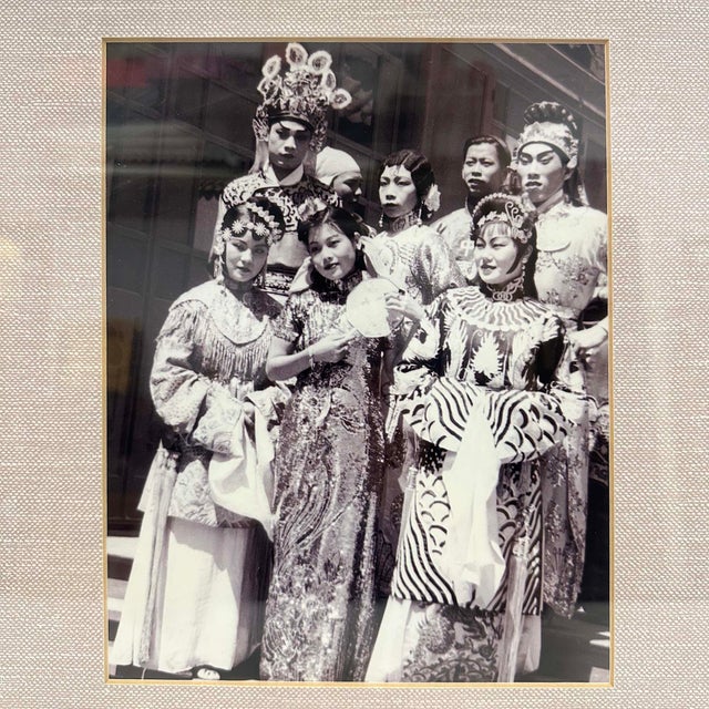 This is a framed vintage photograph capturing a group of performers in ornate, traditional costumes, highly characteristic...