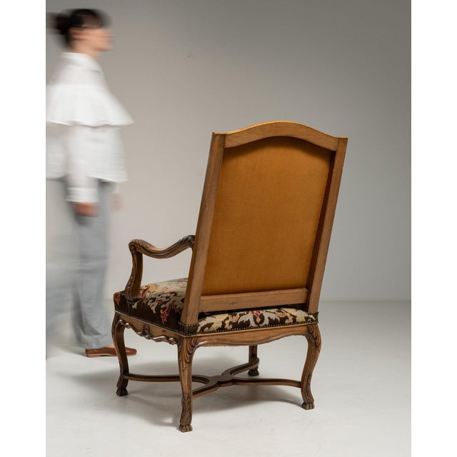This armchair makes its impression through dark walnut carved frame, floral tapestry upholstery. It was made in France...