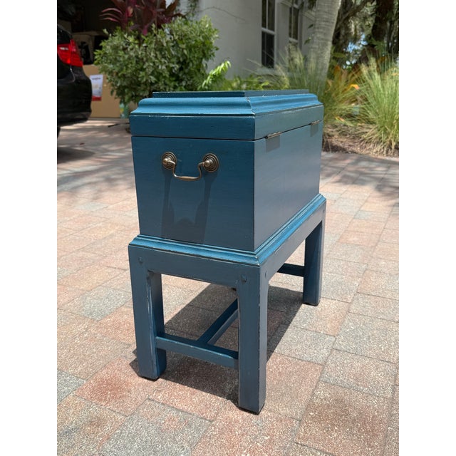 Authentic Somerset Bay painted storage box on stand in a deep blue finish. The piece features a hinged lid, warm wood...