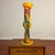 Striking hand-blown art glass floor vase in a bold, sculptural form with a vibrant yellow ground and swirling ribbons of...