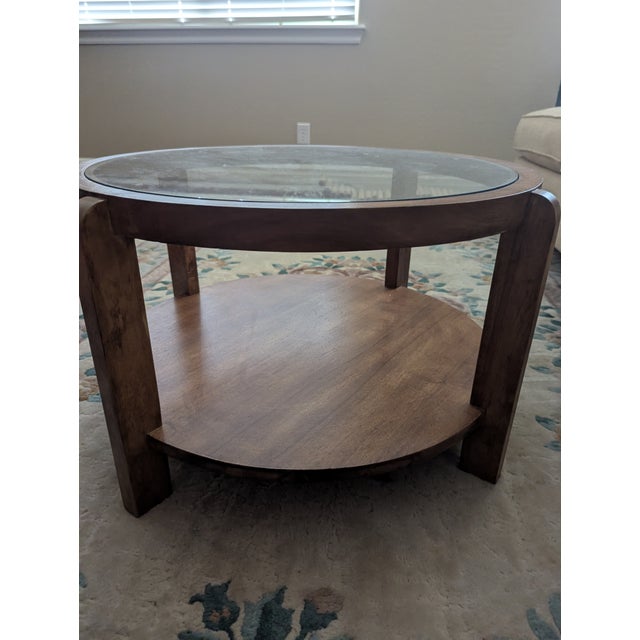 Round coffee table with glass top and bottom shelf. Manufacturer unknown, but the quality is similar to the owner's other...