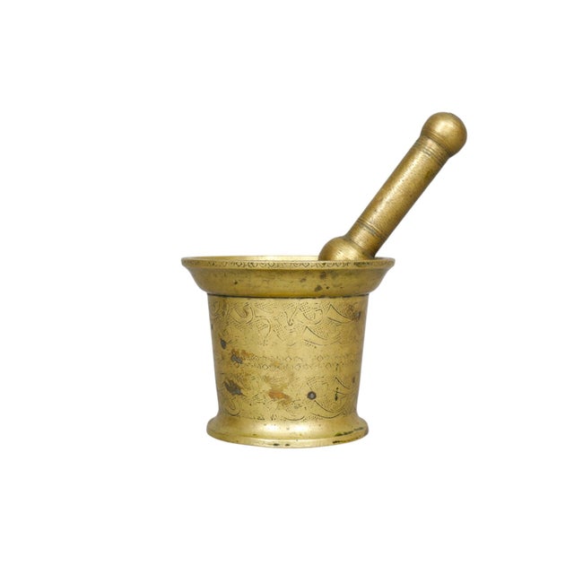 A heavy antique brass pharmacy pestle and mortar. The pestle is baton shaped with large knob ends for crushing and...