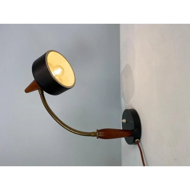 Table lamp of black metal and teak of Danish design from the 1960s. The lamp is in great vintage condition. European Plug...