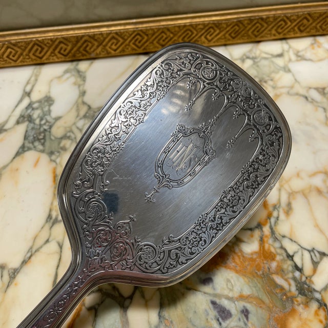 Beautiful hand held mirror with a floral design. Has initials “HNS” inscribed on the back. Thick glass covering the mirror