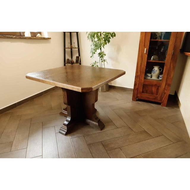 Rustic oak table with a central base, handcrafted in solid wood. The thick oak tabletop highlights the natural wood grain,...