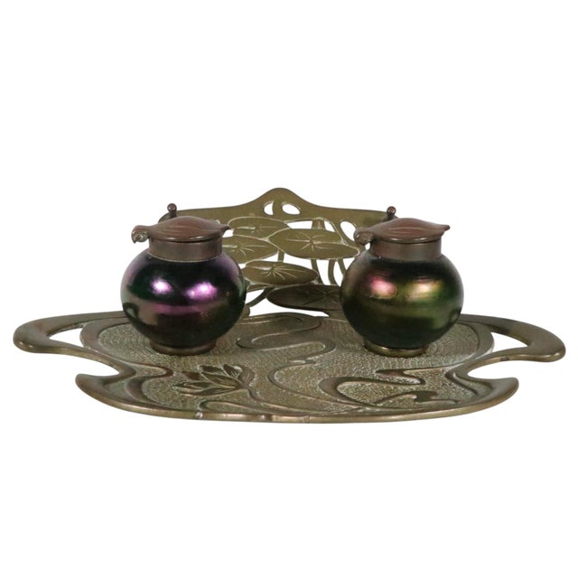 Extraordinary Art Nouveau inkwell, having an organic brass base depicting water lilies, and lily pads, and two lidded art...