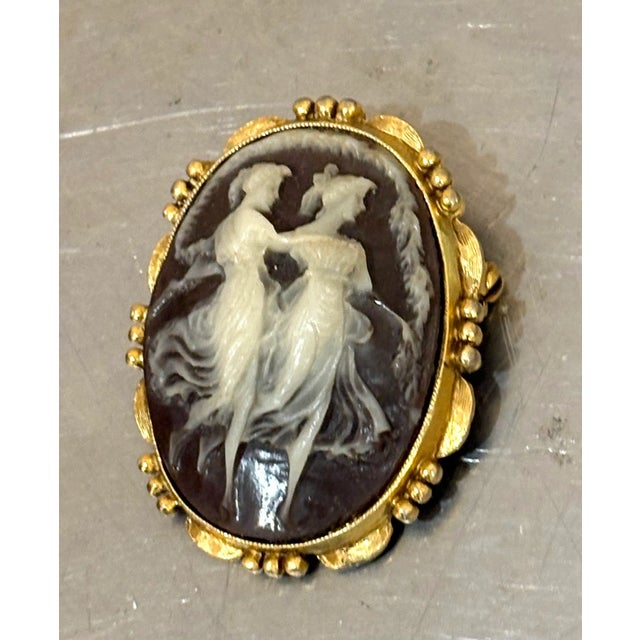 1940s-50s large brown/white carved dancing ladies cameo brooch w/ gold tone setting. Excellent condition.