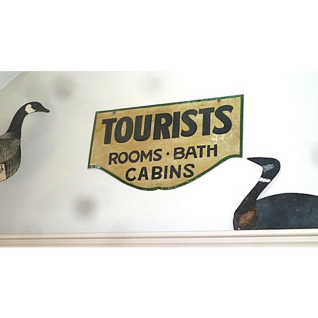 Metal Tourist sign with hand-lettered or stencil-painted double-sided black lettering on a cream background with green...