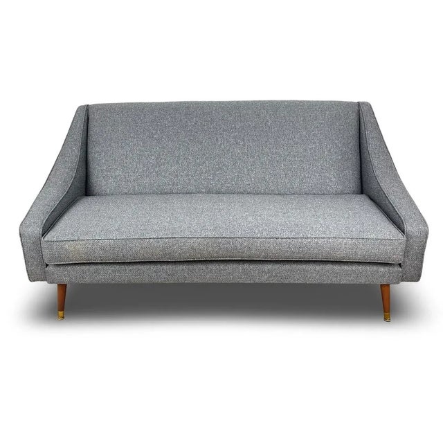 Mid century vintage there seater sofa made in the late 1950s standing on turned wooden legs with brass feet. In excellent...