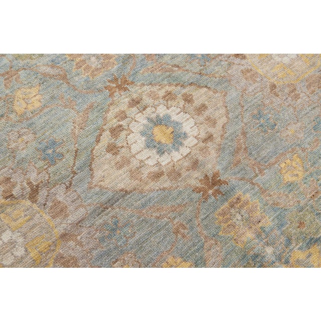 Beautiful modern Sultanabad hand-knotted wool rug with a blue color field. This rug has a designed frame with brown,...