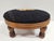 This Victorian style round needlepoint footstool features a floral motif against black background. The base of the stool...