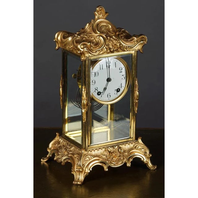 Fire-gilt fireplace clock, Rokokodekor sign. Ansonia New York, 19th century. Bronze-gilt. Four-sided glazed housing on...
