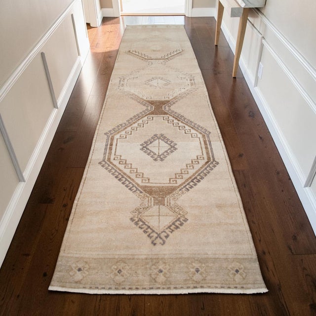 This vintage runner rug originates from a Southeastern Anatolian village, hand-knotted in the mid-20th century using...
