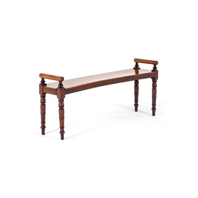 A superb mahogany hall bench of excellent quality with a simple broad generous seat accompanied with turned bolsters to...