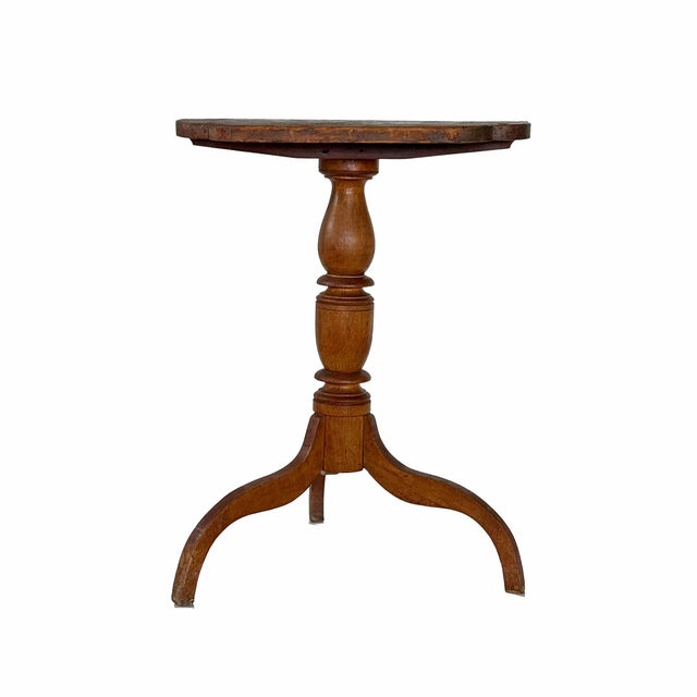Antique candle table. Three legs support turned wood pedestal and top. The top has wear consistent with use and age...