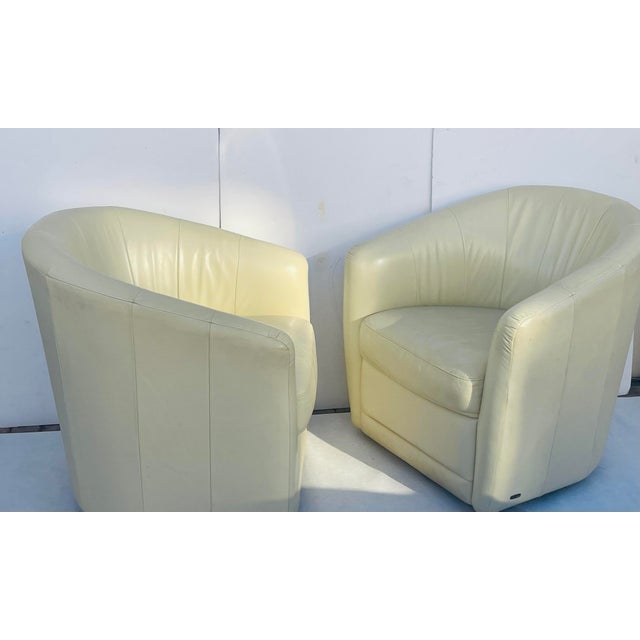 20 th c Pair of Batuzzi barrel back cream leather swivel chairs. Elegant design, comfortable seating.