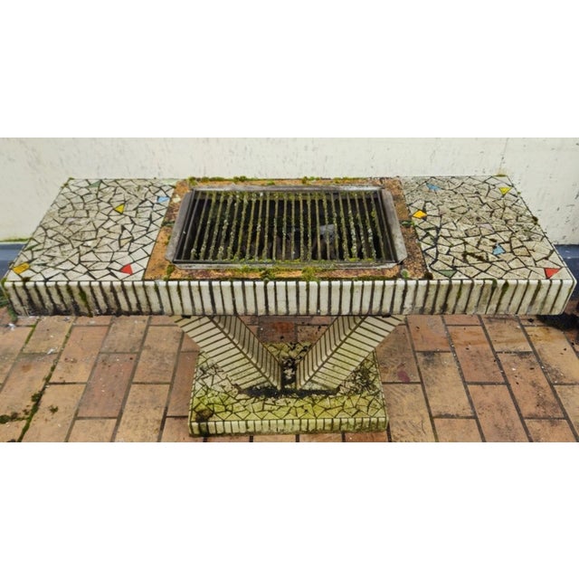 In the style of Ferdinand Cheval's creations: vintage console table with a built-in barbecue. Ceramics in various colors,...