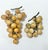 Two alabaster grape clusters in golden yellow, cream and muted green tones with branching green stems. The clusters differ...