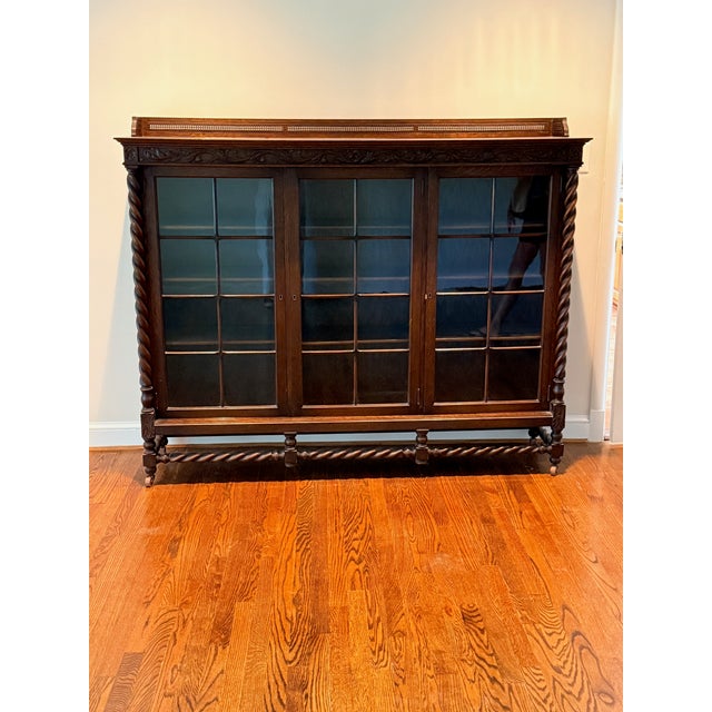 19th century Jacobean Bookcase A beautiful large scale cabinet with three glass doors with a barley twist base as well as...