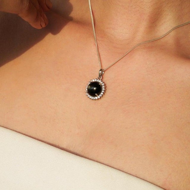 This elegant 7.91 carat round Black Star halo pendant is crafted in 925 sterling silver for a sleek and modern look. The...