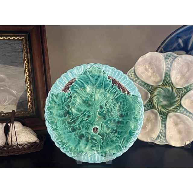 English majolica plate with a scalloped rim and begonia leaf in the center.