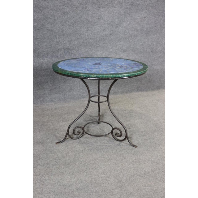 This exceptional French center table is a striking marriage of natural luxury and elegant wrought iron craftsmanship,...