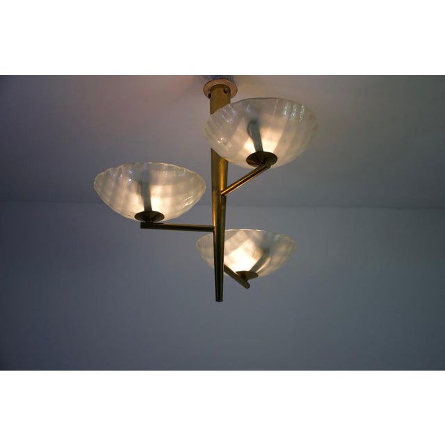 Rare italian brass and glass chandelier, 1950s. This elegant mid-century ceiling light features a refined brass structure...
