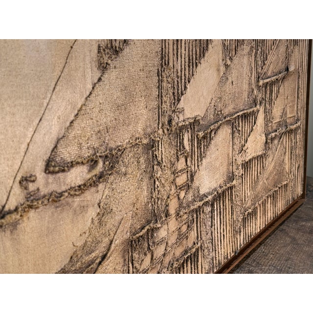 This large unsigned mixed media work combines stretched canvas with layered burlap or similar coarse fabric built up under...