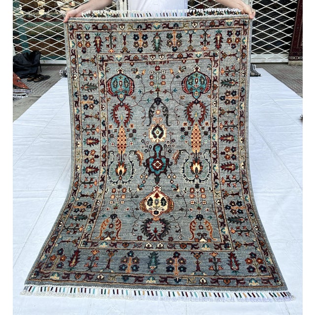 Persian Sarouk design hand-knotted rug featuring vertical columns of elegant turquoise palmette medallions and rust...