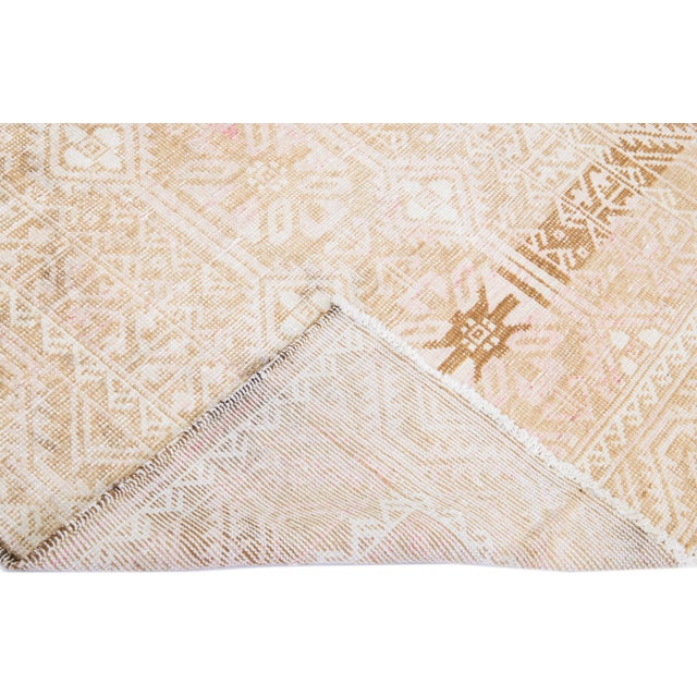 Beautiful vintage Persian Balouch hand-knotted shabby chic wool rug with a beige field. This piece has brown accents in an...