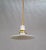 A contemporary pendant light with a rope-covered cord, small milk glass saucer shade, and ceramic and brass canopy....